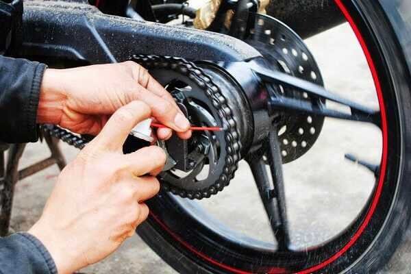 Hình ảnh một chai xịt bôi trơn chuyên dụng dành cho xích xe máy đang được sử dụng