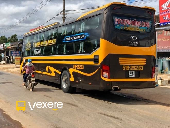 Hình ảnh một chiếc xe khách Phương Hồng Linh màu trắng di chuyển trên đường cao tốc