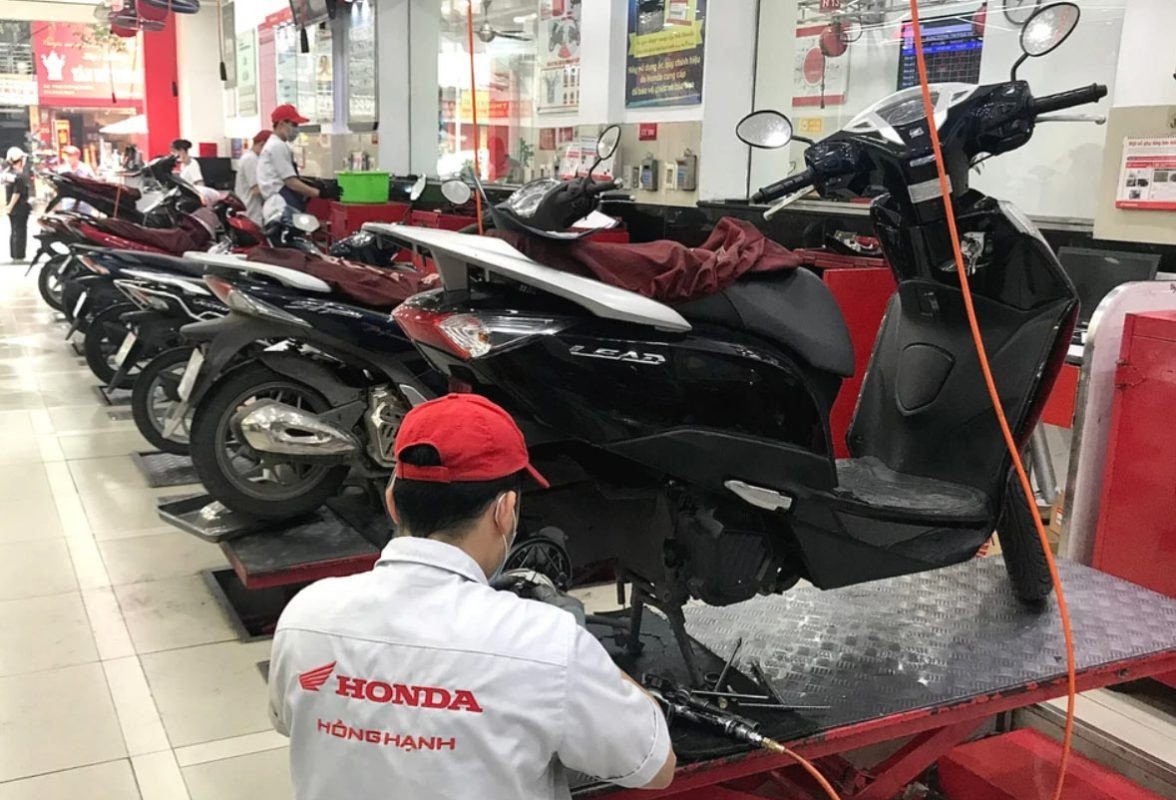 Kỹ thuật viên cứu hộ đang thực hiện sửa chữa xe máy ngay tại hiện trường