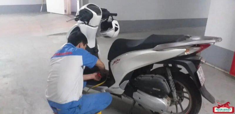 Kỹ thuật viên kiểm tra tình trạng xe máy giữa đường tại khu vực trung tâm Hà Nội