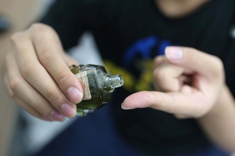 Ảnh chụp chai dầu gió và băng cá nhân, minh họa phương pháp dán dầu gió lên rốn