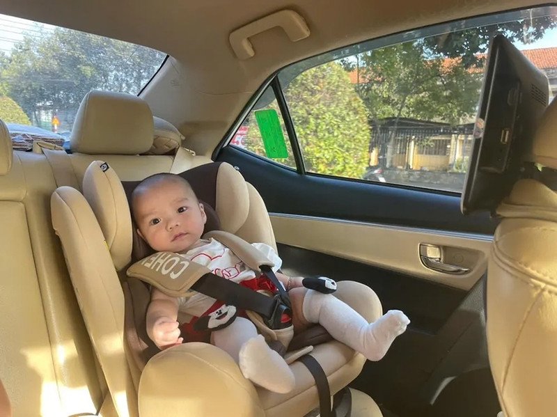 Bé gái ngồi ghế an toàn chuyên dụng trên xe ô tô