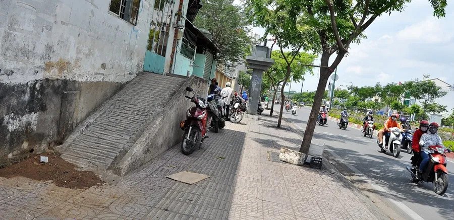 Chiếc xe máy được dắt lên một lối dốc tạm bợ cho thấy sự chênh lệch độ cao