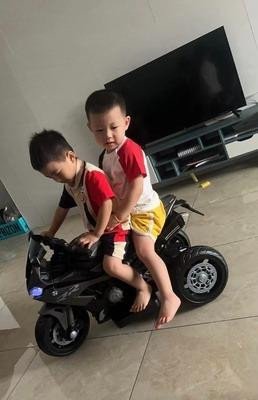 Hình ảnh cận cảnh một chiếc xe máy điện trẻ em màu đỏ, thể hiện chi tiết thiết kế và vật liệu