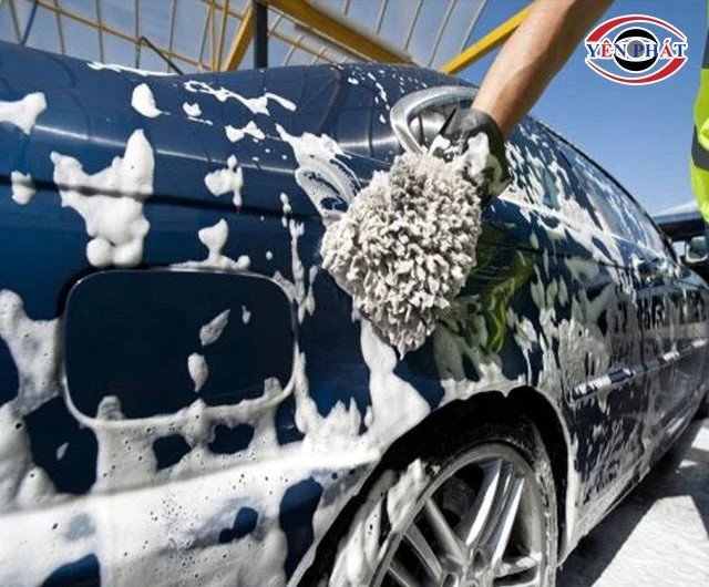 Hình ảnh cận cảnh một thợ đang dùng khăn lau khô và đánh bóng một phần thân xe máy