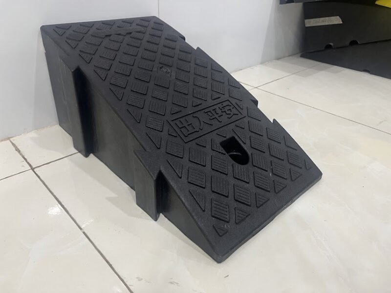 Hình ảnh cầu dắt xe máy bằng nhựa màu đen đặt trên vỉa hè