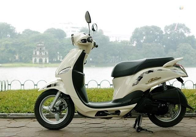 Hình ảnh chiếc Yamaha Nozza màu xanh nhạt đang đỗ cạnh một cửa hàng tạp hóa