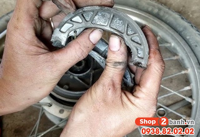 Hình ảnh kỹ thuật viên đang kiểm tra hệ thống phanh đùm của xe máy