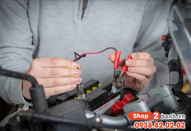 Hình ảnh kỹ thuật viên đang kiểm tra hoặc thay thế ắc quy trên xe tay ga Honda Vision