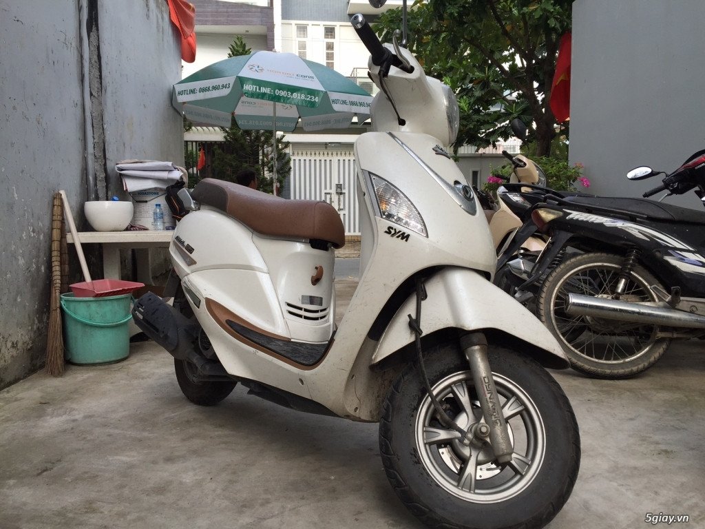 Hình ảnh minh họa một người đang kiểm tra động cơ xe máy cũ cẩn thận