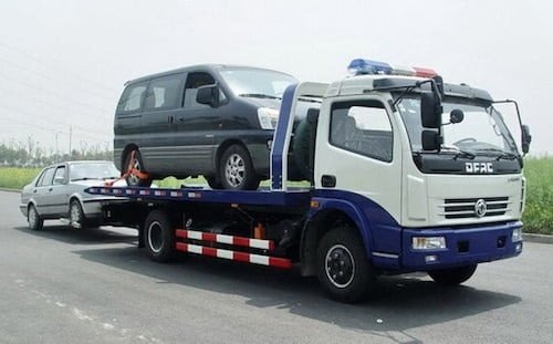 Hình ảnh mô tả một chiếc xe cứu hộ đang hỗ trợ một chiếc ô tô gặp sự cố trên đường phố Hà Nội