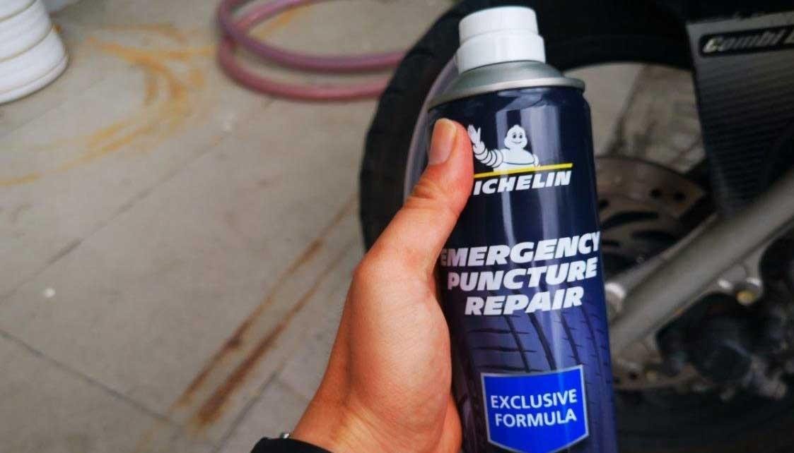 Hình ảnh một chai keo vá lốp xe máy được đặt cạnh một chiếc lốp không săm đã được vá thành công