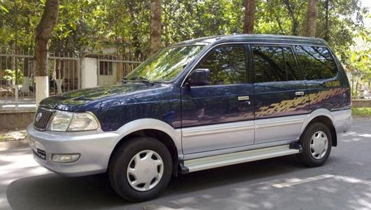 Hình ảnh một chiếc Mitsubishi Jolie màu bạc đang di chuyển trên đường phố