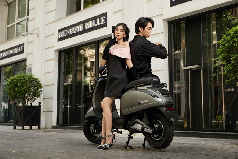 Hình ảnh một chiếc Vespa cổ điển màu vàng đang chạy trên đường phố Ý
