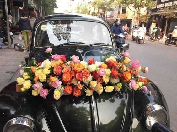Hình ảnh một chiếc xe hoa cưới được trang trí nhẹ nhàng bằng hoa tươi ở phần mui xe