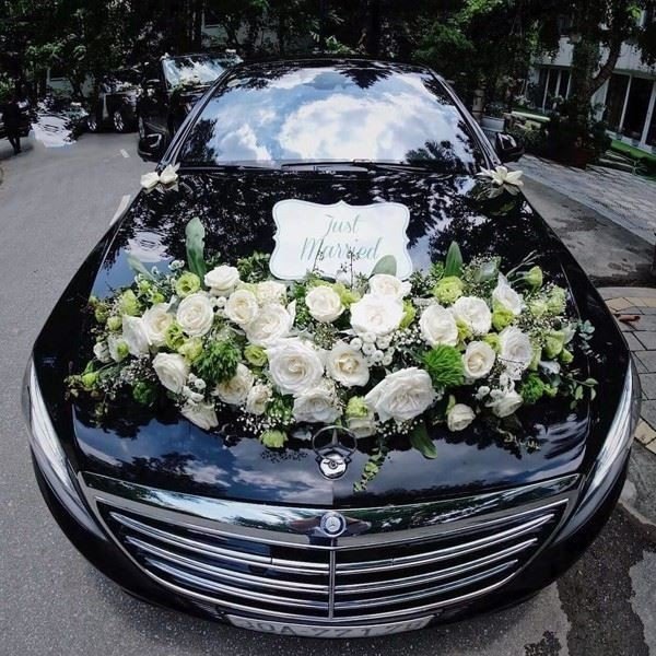 Hình ảnh một chiếc xe hoa cưới màu đen được trang trí với hoa hồng trắng tạo sự tương phản nổi bật