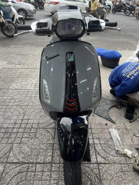 Hình ảnh một chiếc xe máy cũ có lớp sơn bị bong tróc và nhiều vết xước.