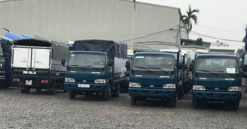 Hình ảnh một chiếc xe tải nhỏ đang chở hàng hóa được đóng gói cẩn thận trên đường phố Hà Nội