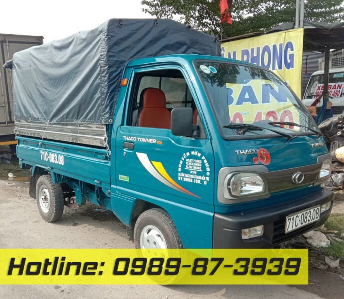 Hình ảnh một chiếc xe tải Thaco Towner 750kg đời cũ màu trắng đang đậu trên đường