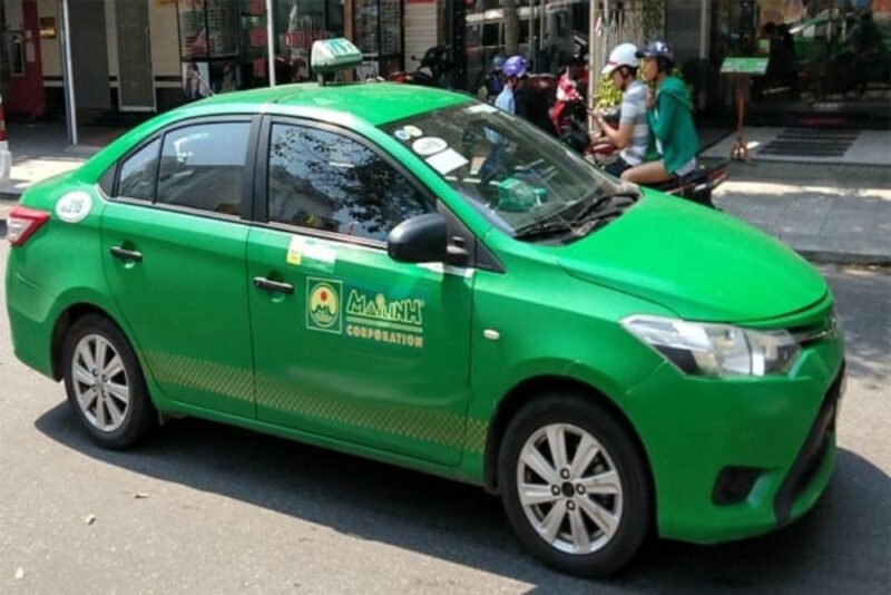Hình ảnh một chiếc xe taxi Mai Linh màu xanh lá cây đặc trưng đang di chuyển trên đường phố Thái Nguyên