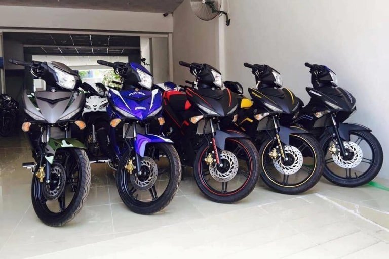 Hình ảnh một dãy xe máy đa dạng mẫu mã được sắp xếp gọn gàng tại bãi đỗ xe