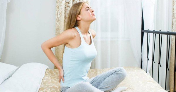 Hình ảnh một người điều chỉnh tư thế ngồi trên xe máy để giảm đau nhức