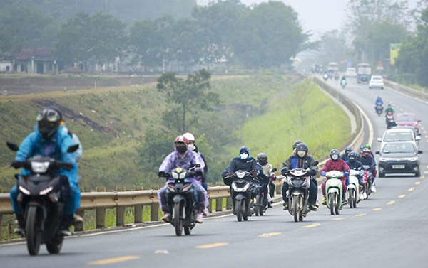 Hình ảnh một người điều khiển xe máy quan sát bản đồ trên điện thoại để định hướng hành trình