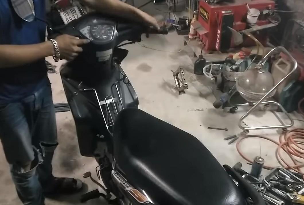 Hình ảnh một người dùng đang kiểm tra bảng đồng hồ xe máy để xác định lỗi đèn báo số