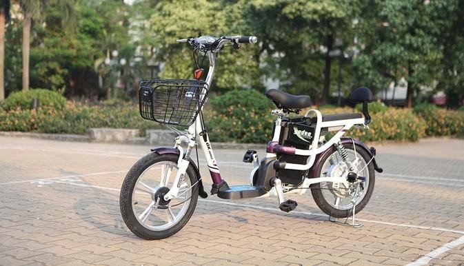 Hình ảnh một nữ sinh đang đạp xe điện với thiết kế gọn gàng, màu sắc tươi sáng