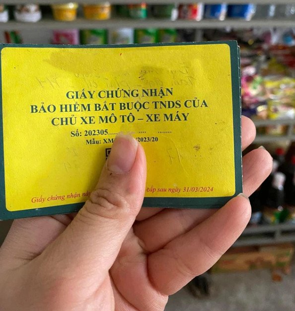 Hình ảnh một tấm thẻ bảo hiểm xe máy được đặt cạnh chìa khóa xe