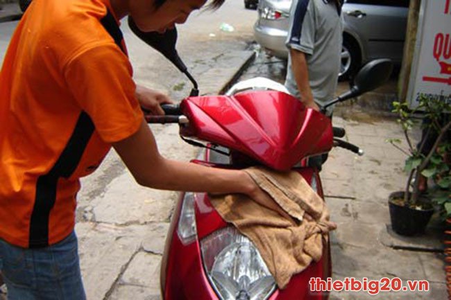 Hình ảnh người dùng đang vệ sinh xe máy sau khi dán decal