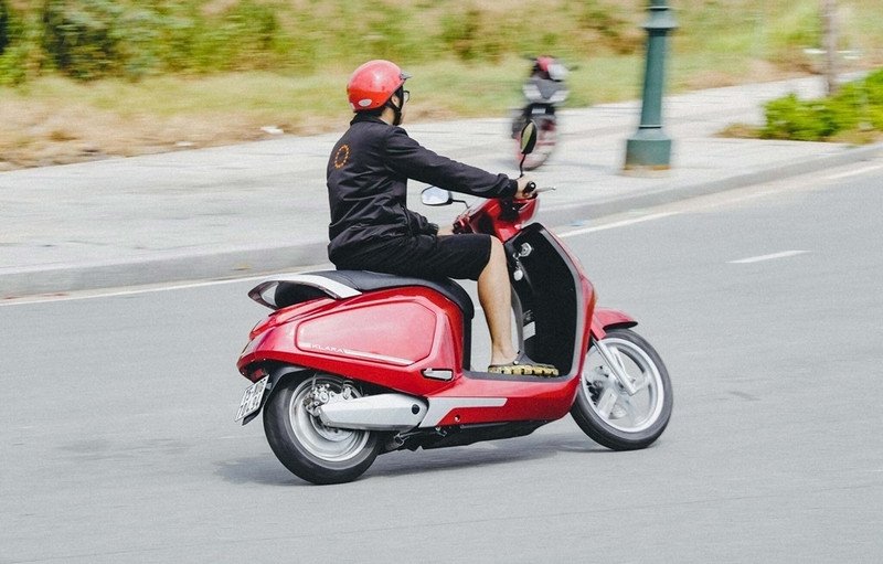 Hình ảnh người lái xe máy đang nắm chặt tay lái, thể hiện sự căng cứng ở cổ tay và bàn tay khi di chuyển đường dài