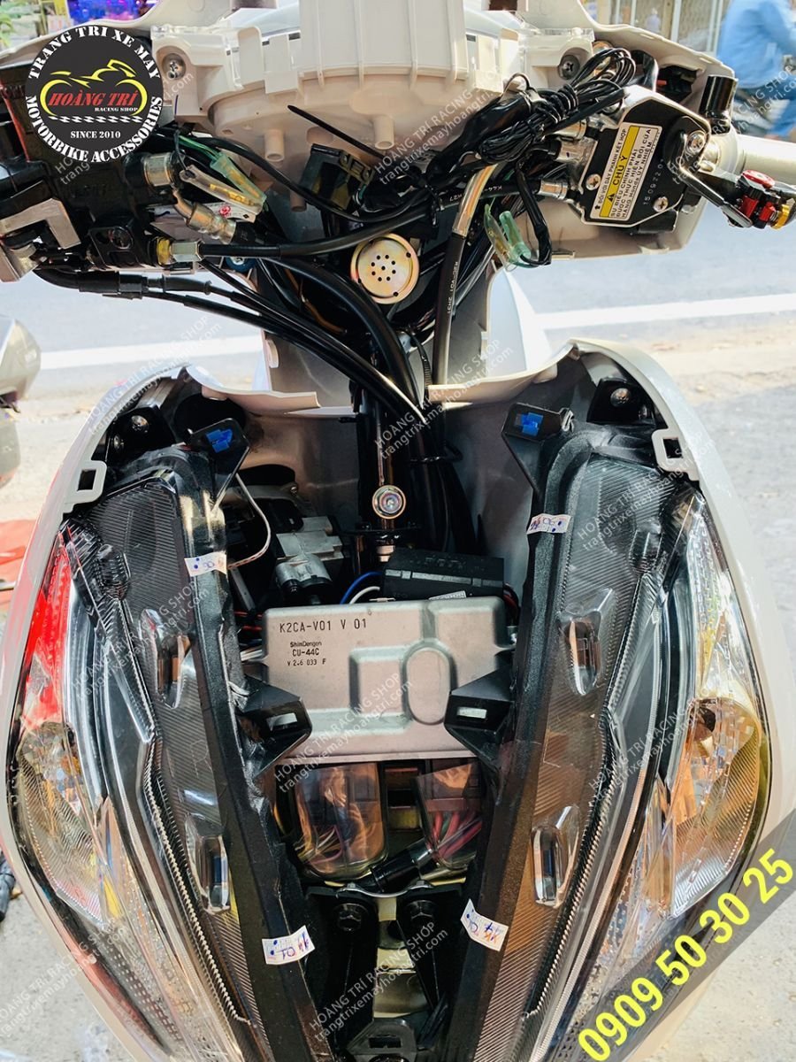 Hình ảnh nhân viên kỹ thuật đang tiến hành lắp đặt còi báo xi nhan cho xe máy tại cửa hàng