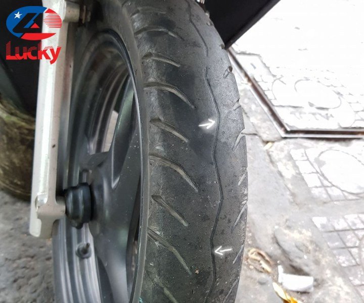 Hình ảnh xe máy đang được kiểm tra tình trạng lốp xe để xác định thời điểm thay thế