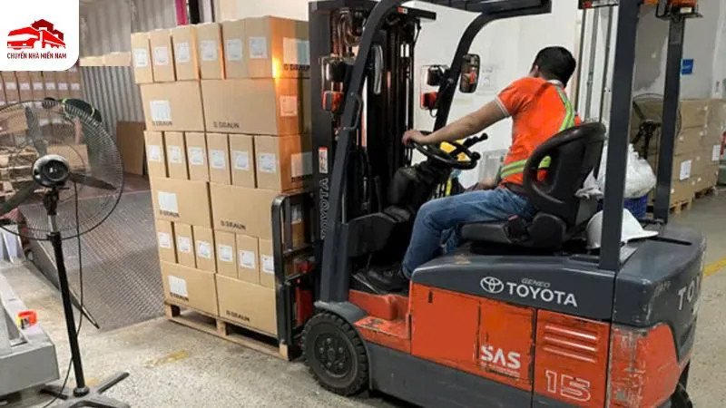 Hình ảnh xe nâng hàng màu vàng đang hoạt động trong kho bãi rộng rãi