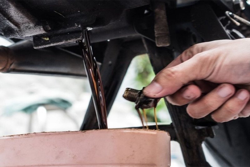 Kỹ thuật viên đang kiểm tra động cơ xe máy sau khi thay dầu