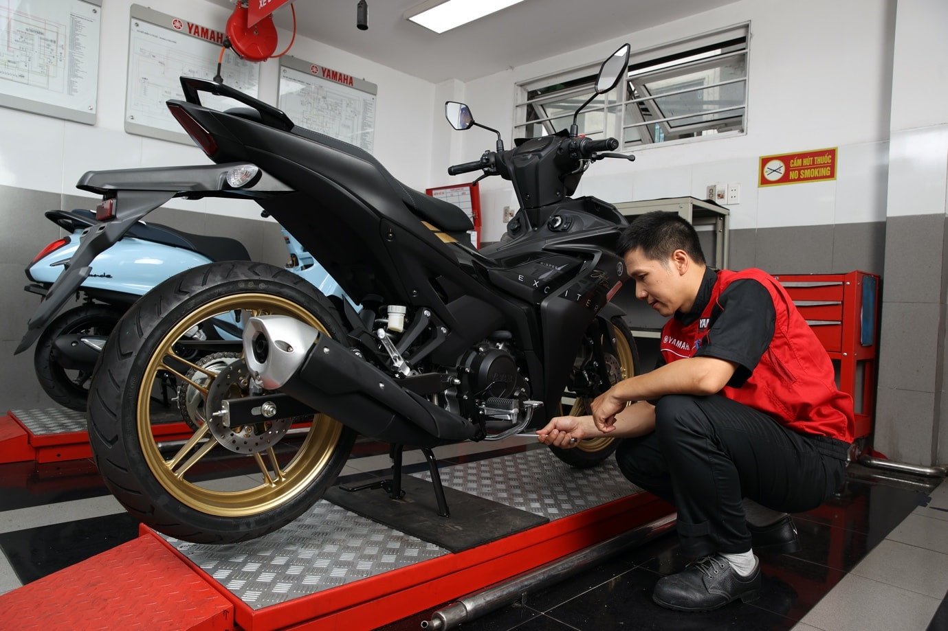 Kỹ thuật viên đang thay nhớt cho xe máy Yamaha