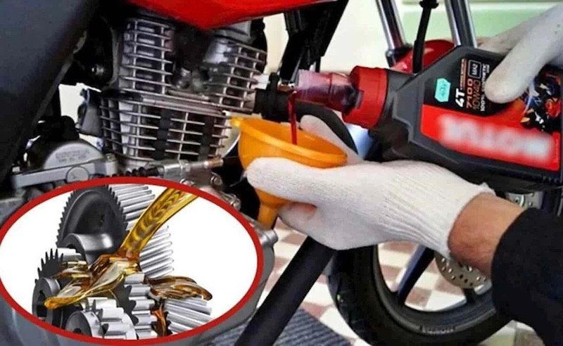 Kỹ thuật viên đang xả dầu nhớt cũ từ động cơ xe máy