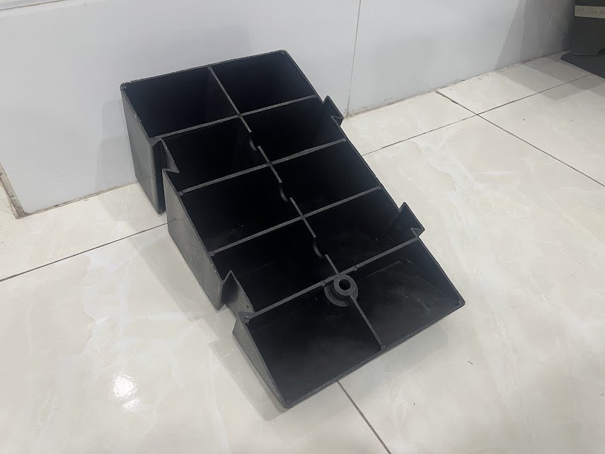 Mặt đáy của cầu dắt xe máy bằng nhựa, cho thấy thiết kế tăng độ bám