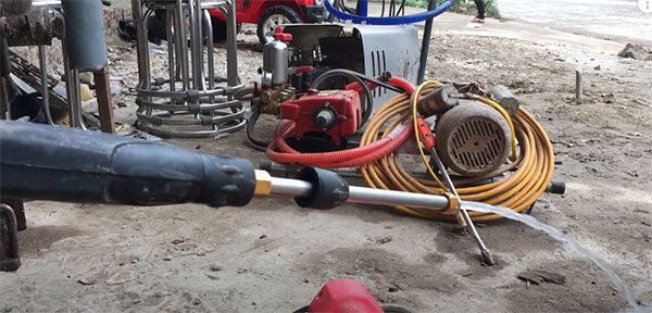 Mô tả hình ảnh: Kiểm tra áp lực nước ra từ súng phun của máy rửa xe mini