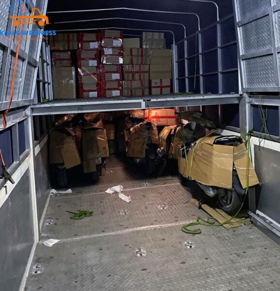 Mô tả hình ảnh: Một chiếc xe máy đang được bốc dỡ cẩn thận khỏi thùng xe tải