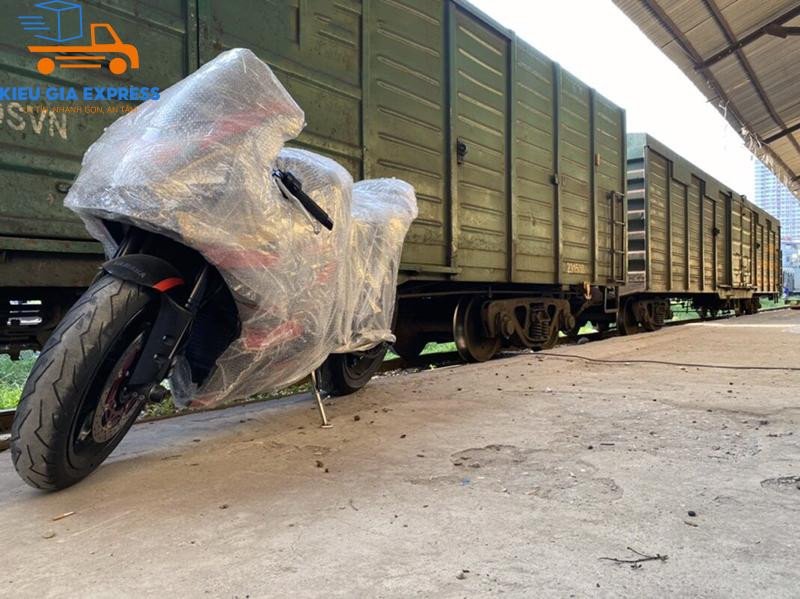 Mô tả hình ảnh: Xe máy được chằng buộc cẩn thận bên trong toa tàu hỏa