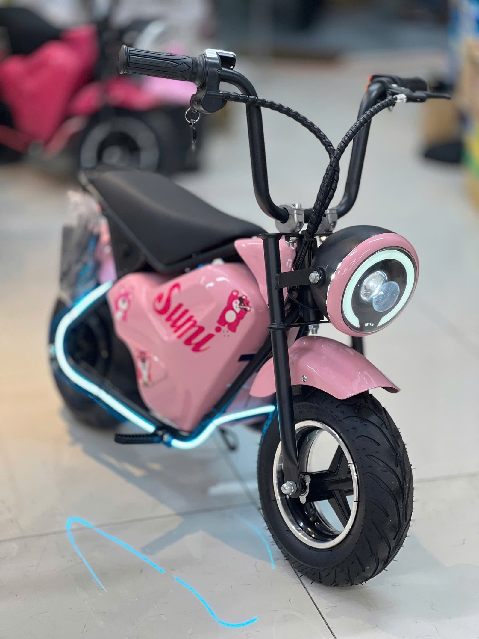 Một bé trai đang vui vẻ lái xe đạp điện trẻ em trên đường vắng