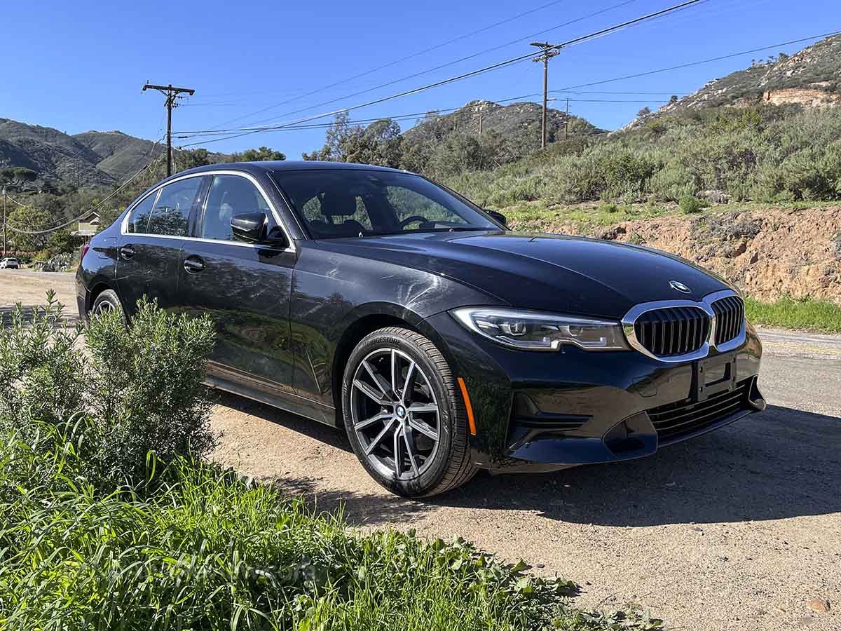 Một chiếc BMW 3 Series màu đen đang di chuyển trên đường