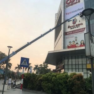 Một chiếc xe cẩu tự hành đang thực hiện công việc nâng hạ vật liệu xây dựng