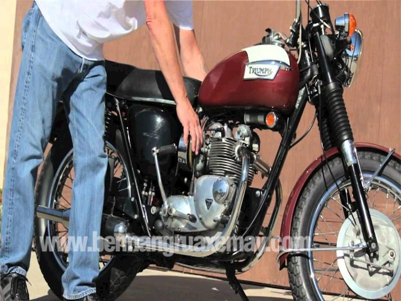 Một chiếc xe máy đang được kiểm tra phần động cơ để tìm nguyên nhân mất áp suất