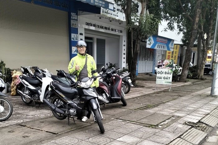 Một chiếc xe máy tay ga hiện đại đang đỗ trên vỉa hè, sẵn sàng cho thuê