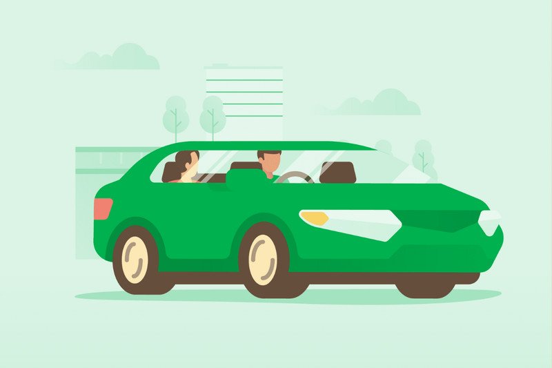 Một chiếc xe ô tô GrabCar đang chở khách đi qua khu vực trung tâm thành phố với nhiều tòa nhà cao tầng.