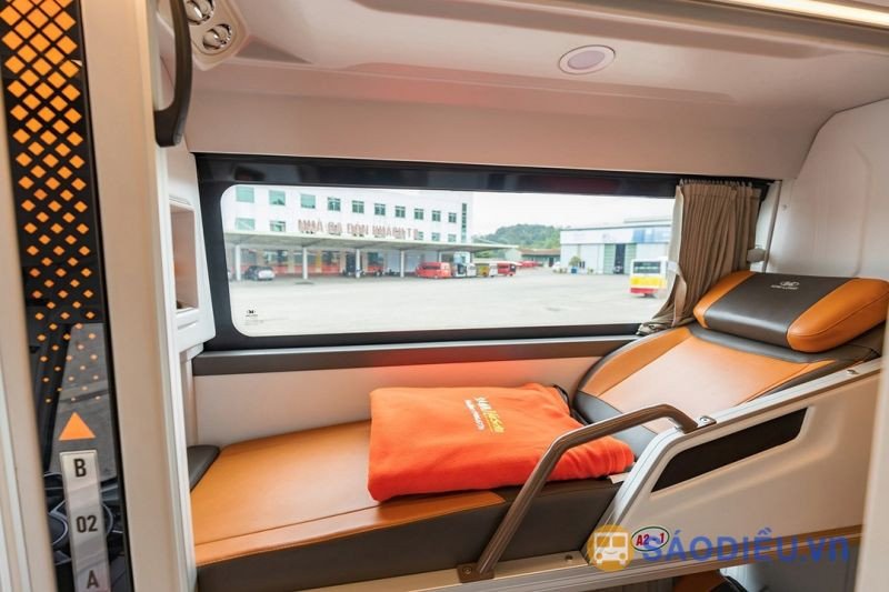 Một hành khách đang nghỉ ngơi thoải mái trên chiếc giường nằm trong xe khách