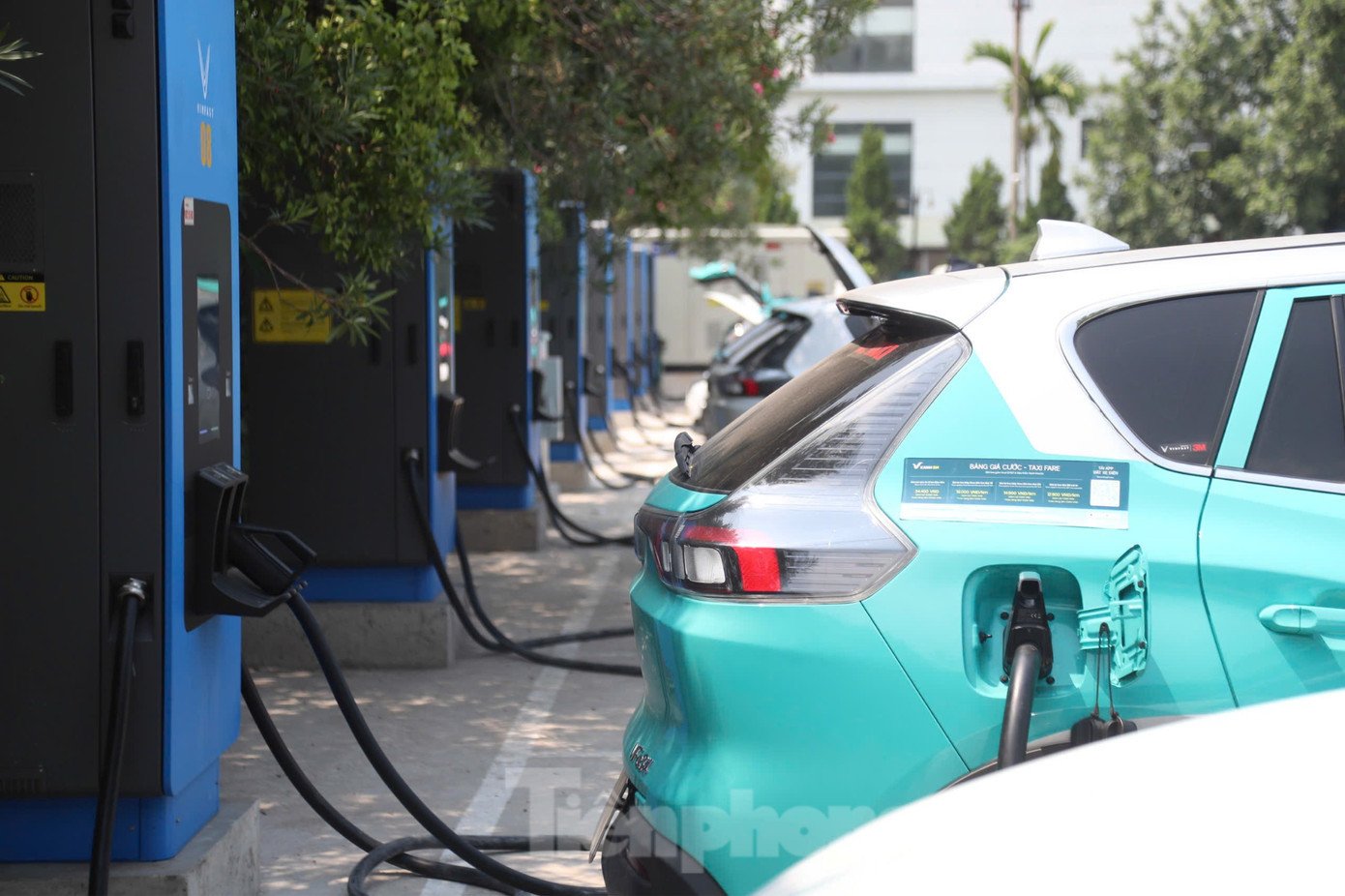 Một kỹ thuật viên đang kiểm tra các trụ sạc xe điện, minh họa cho quy trình kỹ thuật